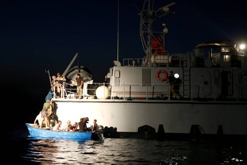 Migrants return to their wooden boat from a Libyan Coast Guard vessel after ‘Sea-Watch 3’ took over a rescue operation in the Maltese search and rescue zone in international waters in the western Mediterranean Sea.