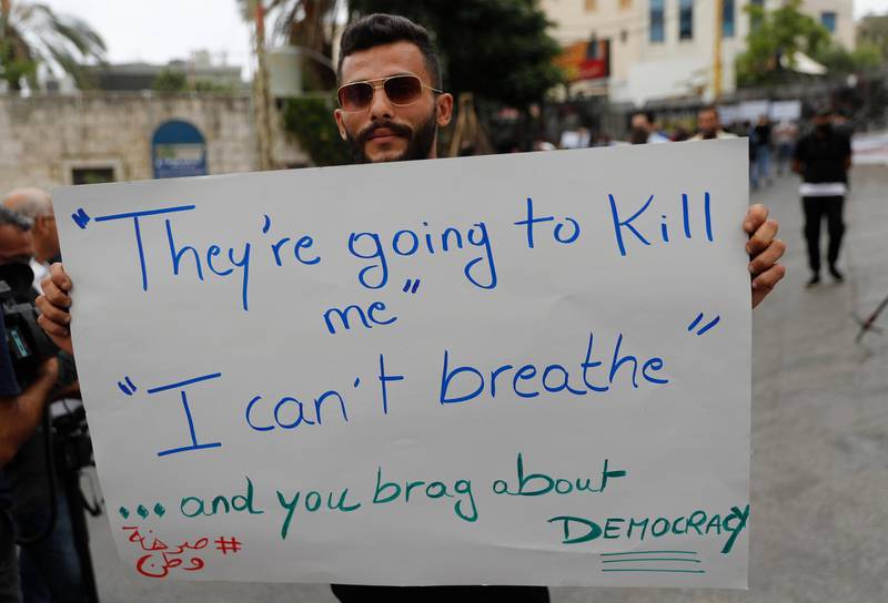 A Hezbollah supporter holds a placard during a protest against US interference in Lebanon's affairs, near the American embassy, in Aukar north-east of Beirut, Lebanon. AP Photo