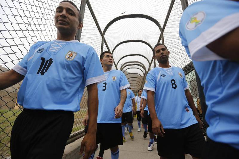 Prisoners, wearing jerseys in the colours of the Uruguay national football team, participate in their own prisoner World Cup at the Castro-Castro prison in Lima on Monday. Mariana Bazo / Reuters / June 2, 2014