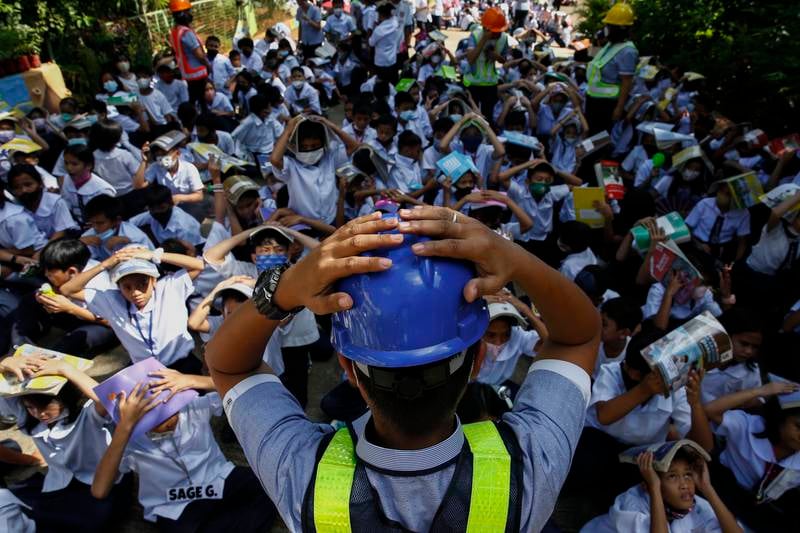 A teacher shows students a protective position during an earthquake drill at an elementary school in Quezon City, Metro Manila, in the Philippines.  EPA