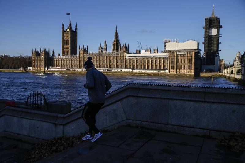 A jogger runs along the Thames Path in view of the Houses of the Parliament in London, U.K., on Monday, Dec. 9, 2019. Prime Minister Boris Johnson said his Conservatives are putting their message across in "every seat" as he goes into the final days of the U.K.’s general election campaign. Photographer: Hollie Adams/Bloomberg