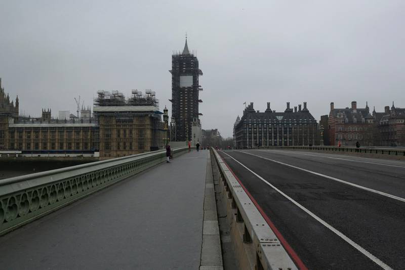 A woman takes a selfie on a near empty Westminster Bridge backdropped by the scaffolded Houses of Parliament in central London. For most people, the new coronavirus causes only mild or moderate symptoms, such as fever and cough. For some, especially older adults and people with existing health problems, it can cause more severe illness, including pneumonia. AP Photo