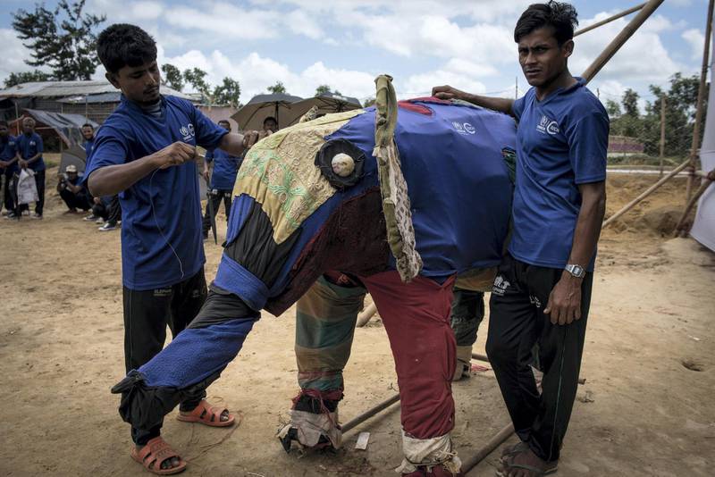 Two members of the Elephnat Response Team with a model elephant in the Rohingya refugee camp near Cox's Bazar, Bangladesh on 12 August 2018. Campbell MacDiarmid for The National