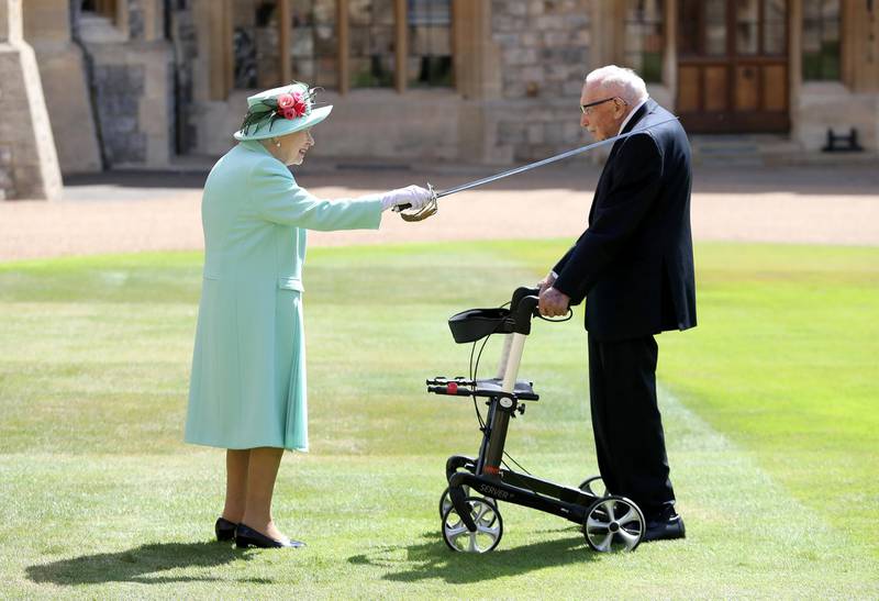 WINDSOR, ENGLAND - JULY 17: Queen Elizabeth II awards Captain Sir Thomas Moore with the insignia of Knight Bachelor at Windsor Castle on July 17, 2020 in Windsor, England. British World War II veteran Captain Tom Moore raised over Â£32 million for the NHS during the coronavirus pandemic.  (Photo by Chris Jackson/Getty Images)