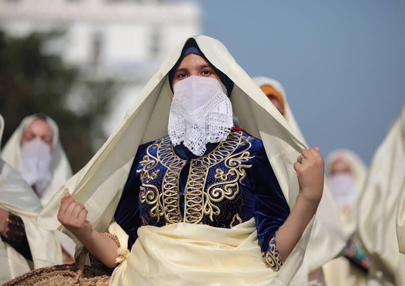 Women wearing traditional clothes take part in the parade. EPA