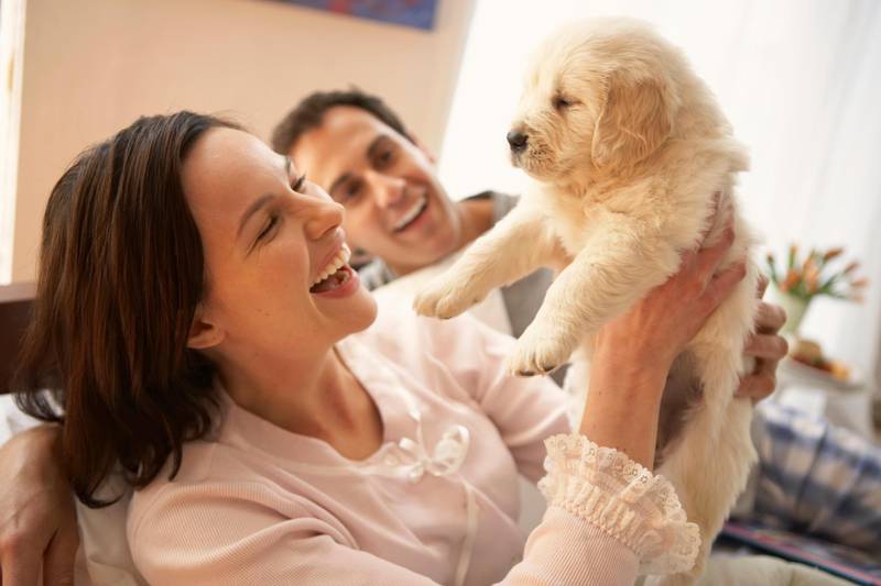 Couple with dog, smiling. Getty Images