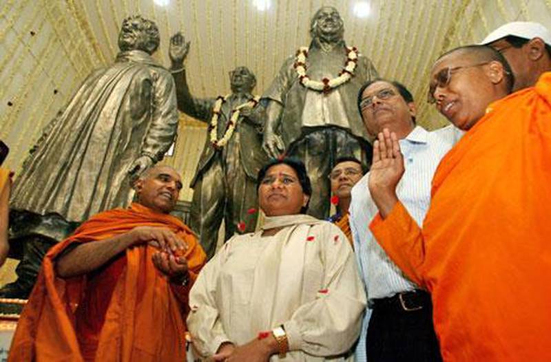 Kumari Mayawati, the chief minister of Uttar Pradash, centre, stands in front of a statue of herself. The Election Commission ruled that she must cover statues because it will give her an unfair advantage with voters.