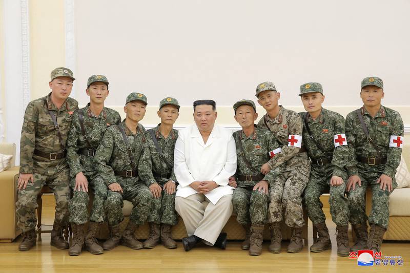 North Korea's leader Kim Jong-un poses for a photo with  Korean People's Army medics during a meeting to recognise their contribution in fighting Covid-19, in the capital Pyongyang. Reuters
