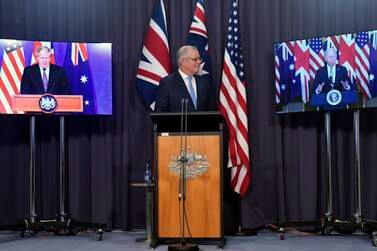 Australia's Prime Minister Scott Morrison, center, appears on stage with video links to Britain's Prime Minister Boris Johnson, left, and U. S.  President Joe Biden at a joint press conference at Parliament House in Canberra, Thursday, Sept.  16, 2021.  The leaders are announcing a security alliance that will allow for greater sharing of defense capabilities — including helping equip Australia with nuclear-powered submarines.  (Mick Tsikas / AAP Image via AP)