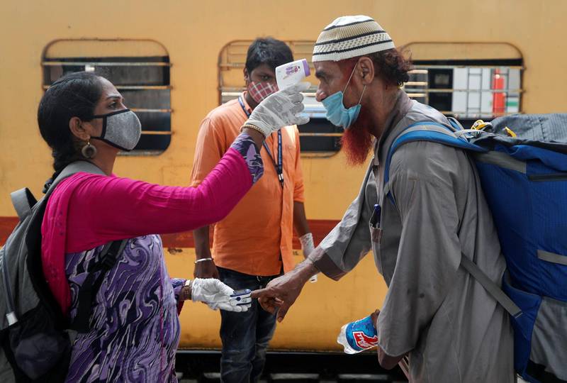 A health worker checks a train passenger’s temperature and pulse on a railway station platform in Mumbai, India, on April 7, 2021. Reuters
