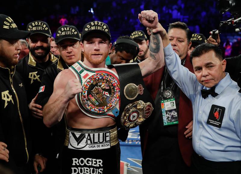 Canelo Alvarez poses for a photo with referee Benjy Esteves Jr., right, after defeating Gennady Golovkin by majority decision in a middleweight title boxing match, Saturday, Sept. 15, 2018, in Las Vegas. (AP Photo/Isaac Brekken)