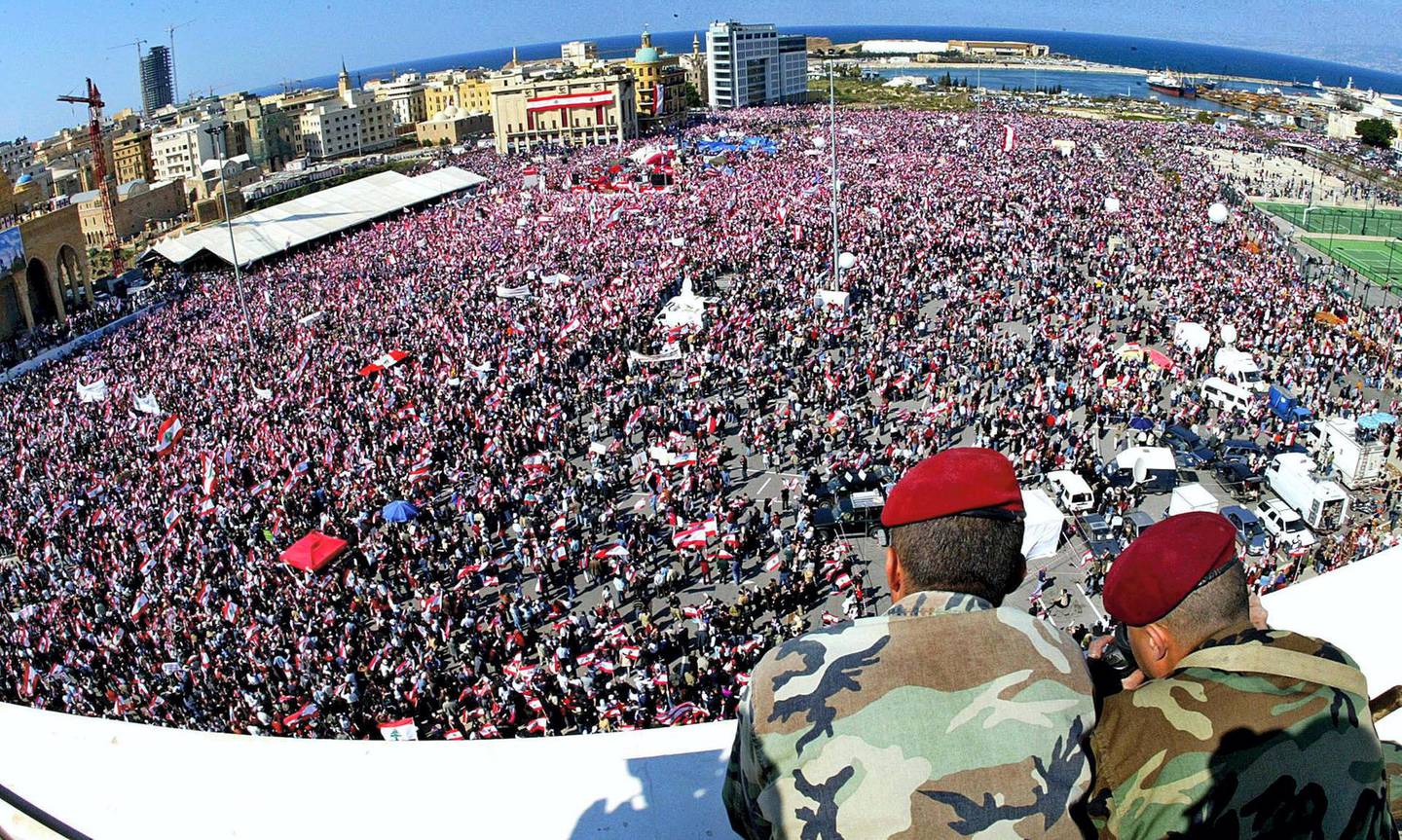 Lebanese soldiers keep an eye on hundreds of thousands of demonstrators at Martyrs Square in Beirut's downtown 14 March 2005. More than 800,000 people poured into the heart of the city for an opposition demanding an end to nearly three decades of Syrian military domination and to mark the fourth week of the death of former Prime Minister Rafiq Hariri.   AFP PHOTO/ANWAR AMRO (Photo by ANWAR AMRO / AFP)