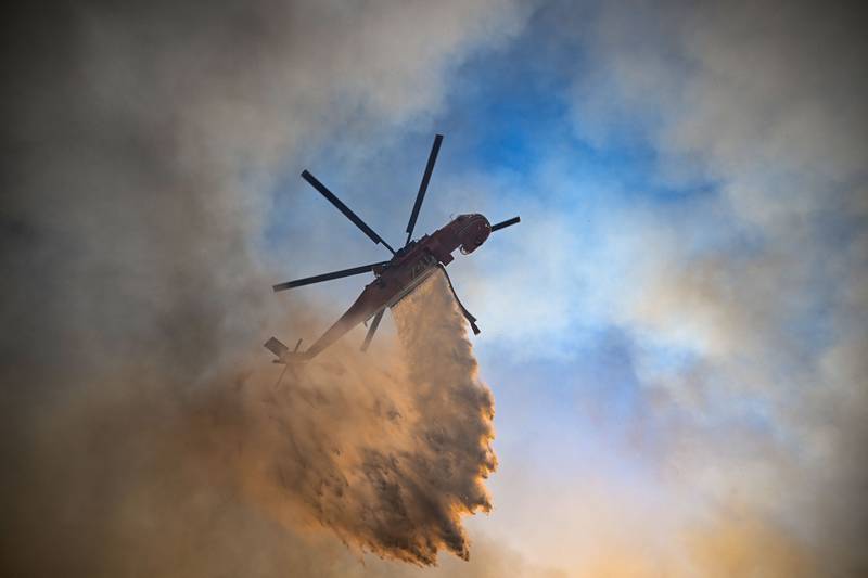 A firfighting helicopter drops water on a blaze on the Greek island of Rhodes. AFP