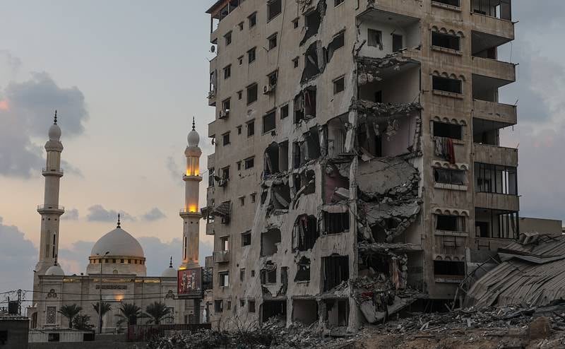 A mosque in Gaza city over which looms a ruined tower block. EPA