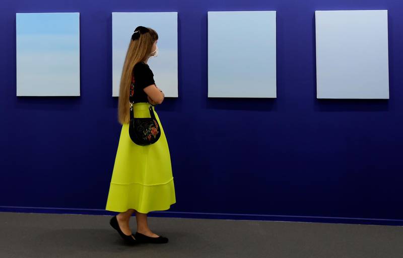 A woman visits oil on canvas paintings by Ayesha Sultana of the Experimenter gallery in 14th edition of Art Dubai. AP Photo/Kamran Jebreili