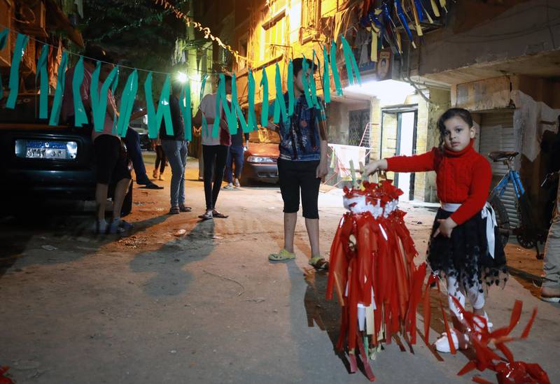 A girl helps decorating a street with ornaments in Giza, Egypt. EPA