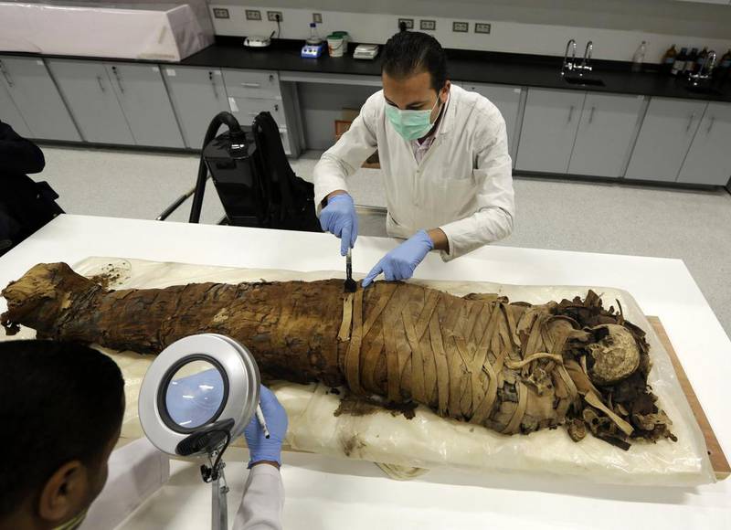 Egyptian conservationists clean a female mummy dated to Pharaonic late period, (712-323 BC), in the conservation centre of Egypt's Grand Museum, that's currently under construction. Amr Nabil / AP