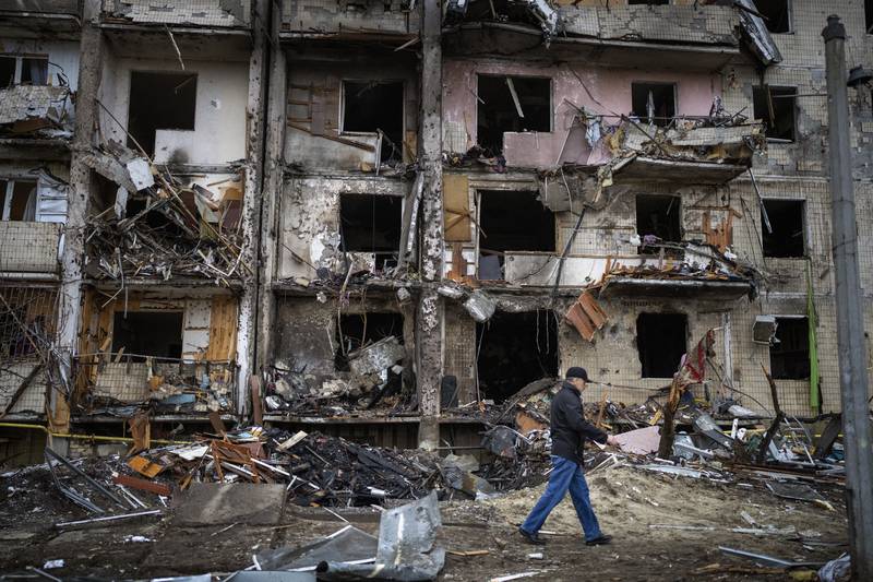 A man walks past a building damaged by a rocket attack in the Ukrainian capital. AP