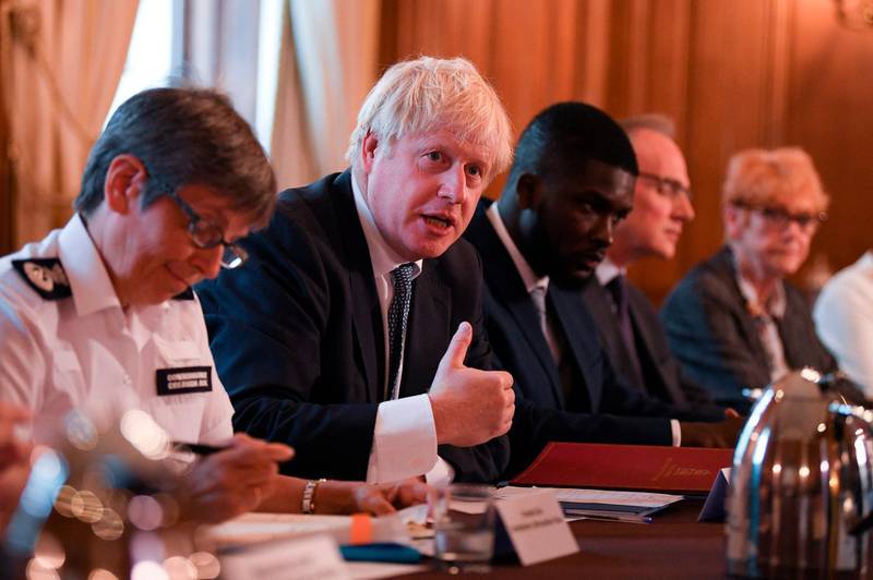 Britain's Prime Minister Boris Johnson (C) speaks flanked by Britain's Metropolitan Police Service (MPS) Commissioner Cressida Dick (L) and Youth Justice Board Adviser Roy Sefa-Attakora (R) during a roundtable on the criminal justice system at 10 Downing Street in London on August 12, 2019.  / AFP / POOL / Daniel LEAL-OLIVAS
