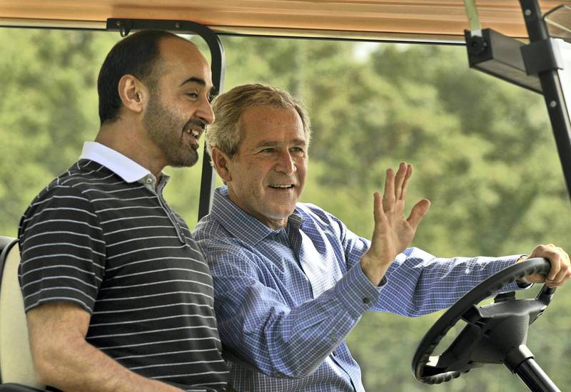 US President George W. Bush (R) waves from a golf cart with Crown Prince of the Emirate of Abu Dhabi Sheikh Mohammad bin Zayed Al Nahyan upon his arrival at Camp David, Maryland, on June 26, 2008.          AFP PHOTO/Jim WATSON (Photo by JIM WATSON / AFP)