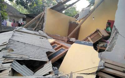 In this image made from video released by Indonesia's Disaster Mitigation Agency, a man inspects the damage caused by an early morning earthquake on the island of Lombok, Indonesia, Sunday, July 29, 2018. A shallow magnitude 6.4 earthquake early Sunday killed a number people and injured dozens on Indonesia's Lombok Island, a popular tourist destination next to Bali. (Indonesia's Disaster Mitigation Agency via AP)