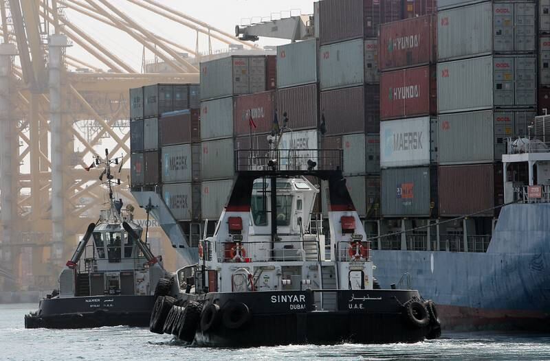 DUBAI , UNITED ARAB EMIRATES Ð Oct 06 : Tugboats pushing the Cargo ship near the terminal 2 of Jebel Ali port in Dubai. ( Pawan Singh / The National ) For Business. Story by Frank Kane