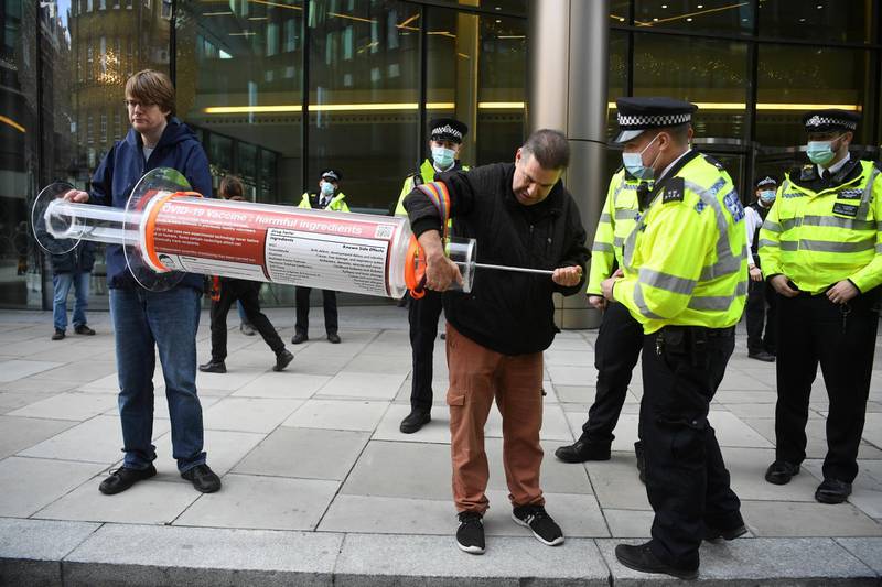 epa08839318 Anti-vax demonstrators talks to police as they hold a large syringe while protesting against Covid-19 vaccination, outside the headquarters of the Bill and Melinda Gates Foundation in London, Britain, 24 November 2020. Vaccine trials from a number of pharmaceutical companies are proving successful, giving hope at ending restrictions due to the ongoing coronavirus pandemic.  EPA-EFE/NEIL HALL *** Local Caption *** 56518024