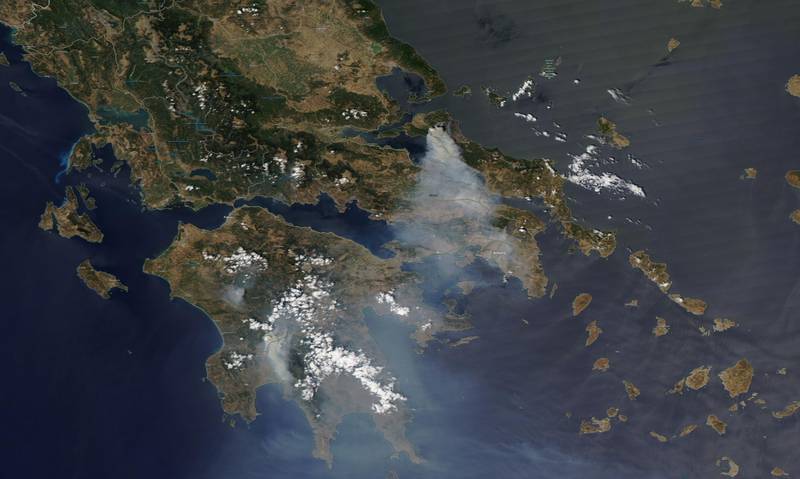 In this satellite image smoke is seen rising high into the sky as wildfires burn north of Athens.