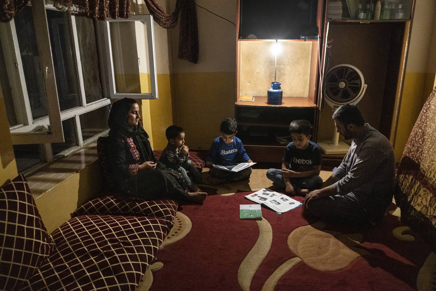 Yousef Mohammed, 35, sits with his three sons as they do their homework by gas lamp during one of the many power cuts in Kabul. Getty Images
