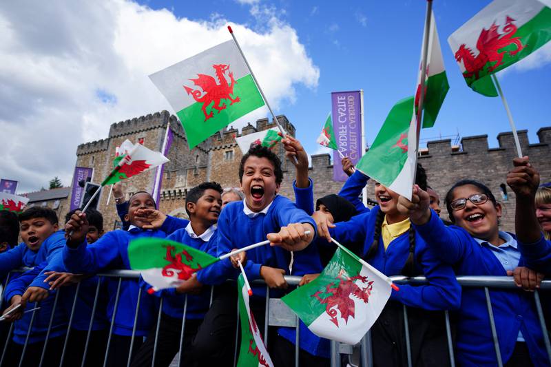 Schoolchildren wait for King Charles to arrive at Cardiff Castle. Reuters