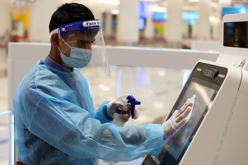 A member of staff cleans to protect travellers from Covid-19 as people travel from Dubai Airport terminal 3 in Dubai.