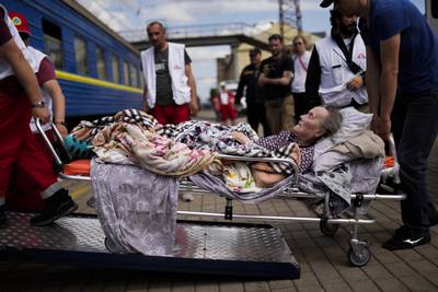 An elderly patient boards a medical evacuation train in Pokrovsk in May 2022
