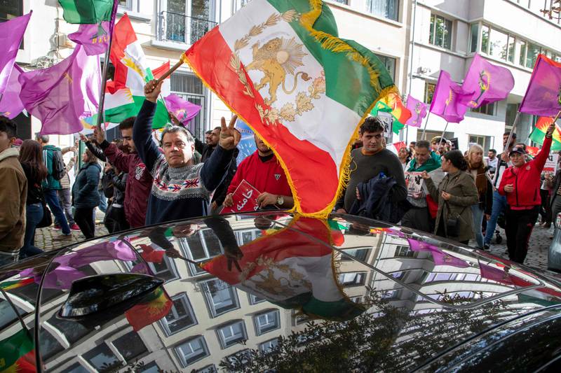 A protestor holds a pre-Islamic Revolution Iranian flag during a demonstration in Brussels in support of the Iranians fighting for their freedom. AFP