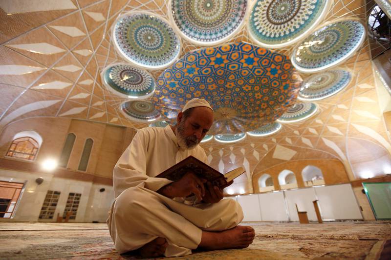 An Iraqi man reads the Koran in an almost empty mosque, following the outbreak of the coronavirus disease (COVID-19), during the holy month of Ramadan in the holy city of Najaf, Iraq. REUTERS