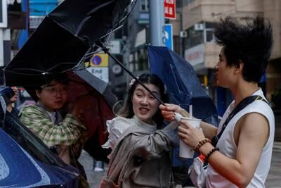 People struggle to hold their umbrellas as Typhoon Koinu approaches Hong Kong. Reuters