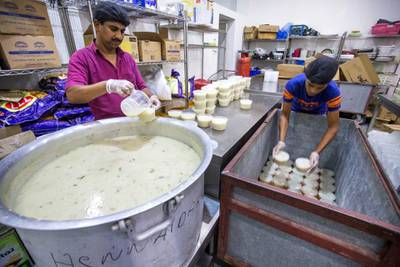 DUBAI,  UNITED ARAB EMIRATES, 20 May 2018 - Staff starts to place the porridge in a small containers and inside the carts to serve during iftar at Wonder  Chef Catering, Al Quoz, Dubai. Leslie Pableo for The National  for Ramola Talwar story