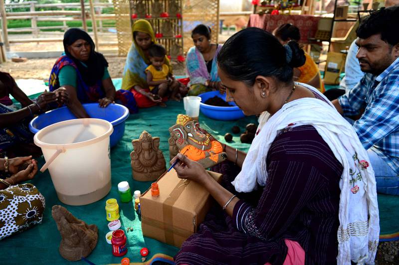 Les artisans travaillent sur des idoles écologiques fabriquées à partir de bouse de vache.  AFP