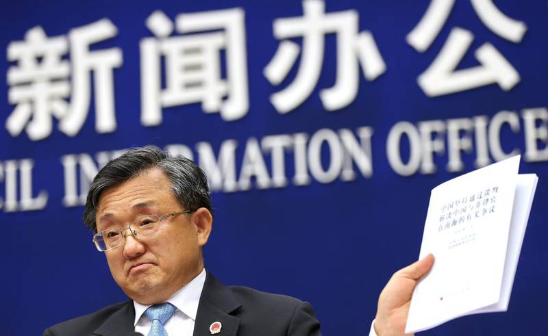 Chinese vice foreign minister Liu Zhenmin holds up a policy paper on China's position on the ruling of an international tribunal on the South China Sea during a press conference in Beijing, on July 13, 2016. The Hague ruled a day earlier against Chinese claims to rights in South China Sea – a ruling Beijing has rejected. How Hwee Young/EPA