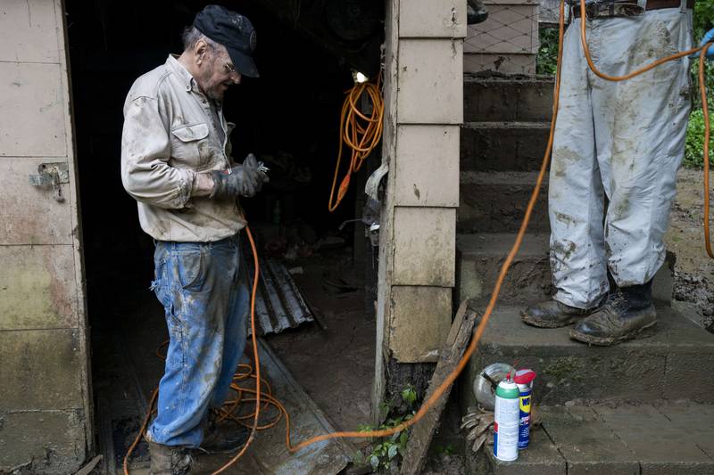 Charlie Jones uses an extension cord to fix his well pump at his house in Breathitt County, Kentucky, Getty Images / AFP
