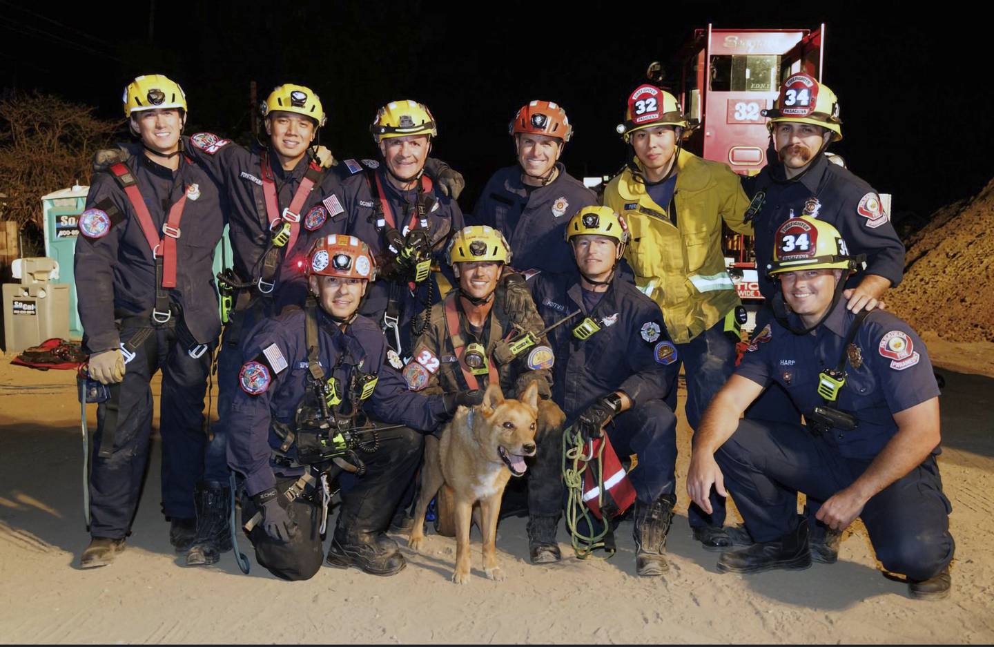 Firefighters take a photograph with Cesar after rescuing the 13-year-old blind dog. Pasadena Fire Department / AP
