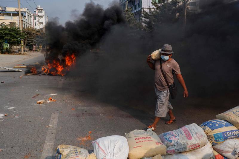 A man carries a sandbag to erect a makeshift barricade, as security forces stage a crackdown on demonstrations by protesters against the military coup, in Mandalay. AFP