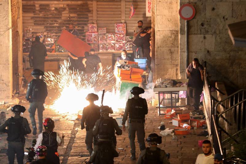 Palestinians react as Israeli police fire a stun grenade during clashes at Damascus Gate on Laylat Al Qadr during the month of Ramadan, in Jerusalem's Old City. Reuters