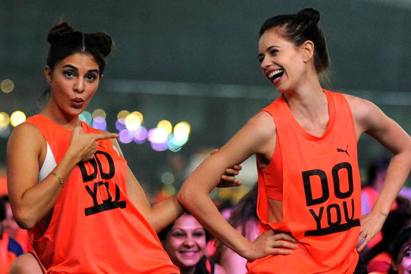 Indian Bollywood actress Jacqueline Fernandez (L) and Kalki Koechlin (R) participate in a challenge that attempted to break a world record for the most people holding an abdominal plank to mark International Day of the Girl Child in Mumbai on November 6, 2016. / AFP PHOTO / -
