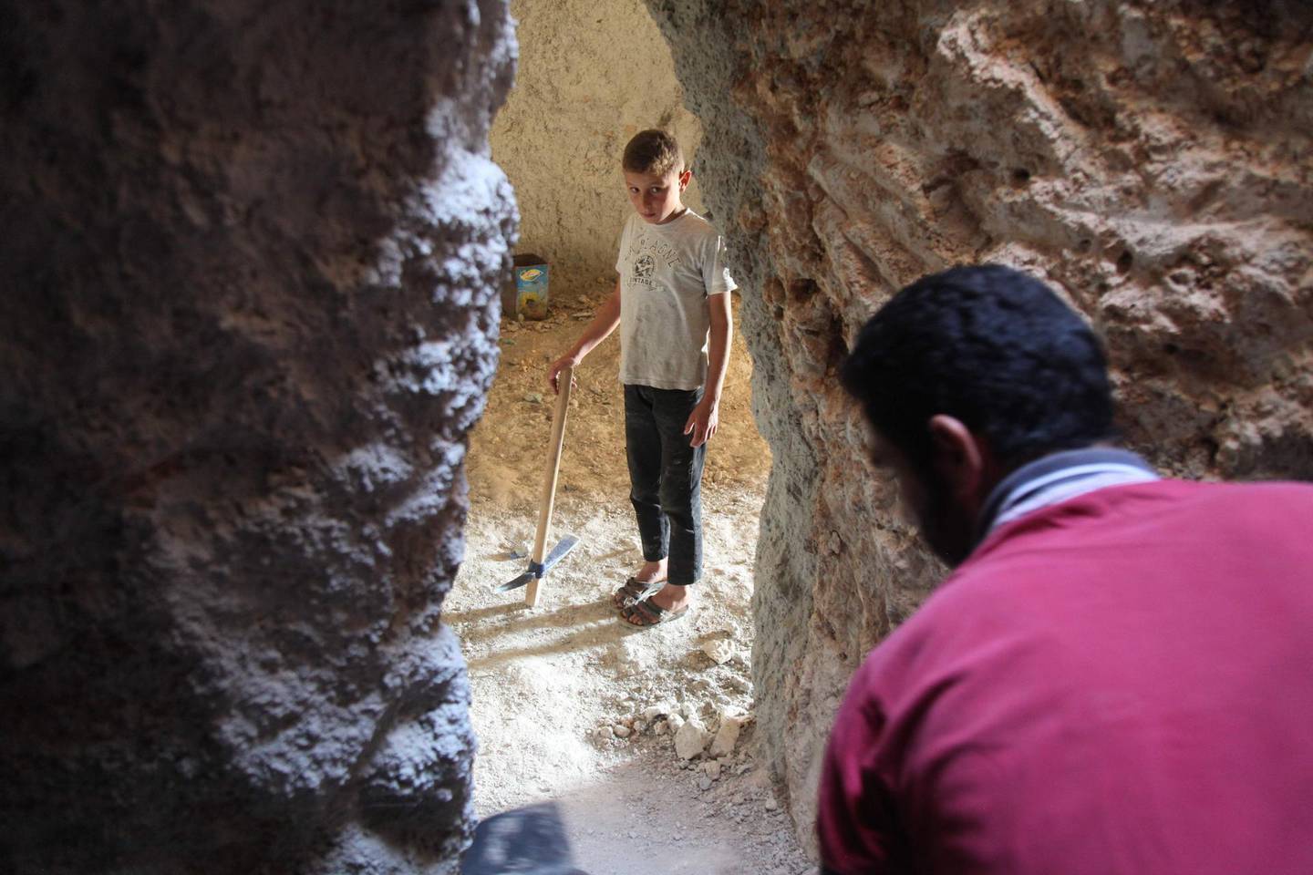 TOPSHOT - A Syrian man digs a cave with his brother at an unknown location in the southern countryside of Idlib province on September 11, 2018, in anticipation for an upcoming government forces offensive. - The Syrian regime and its Russian ally are threatening an offensive to retake the northwestern province of Idlib, Syria's last rebel bastion. (Photo by Amer ALHAMWE / AFP)