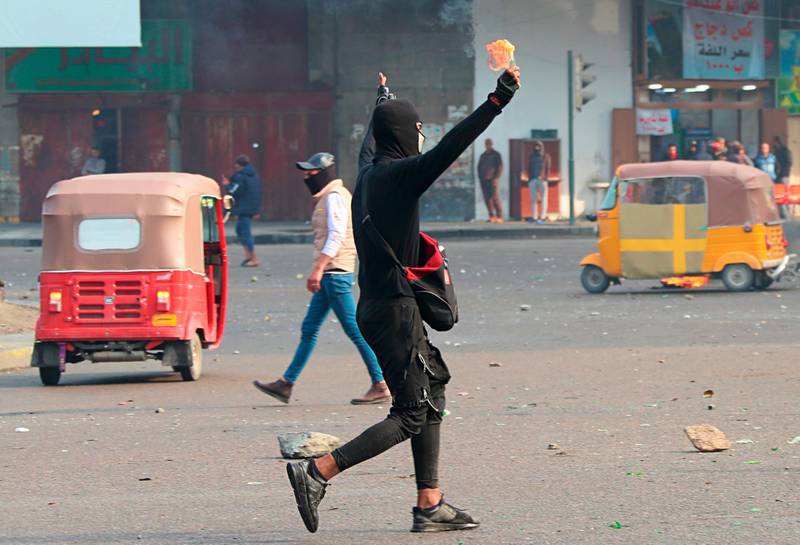 An anti-government protester prepares to throw a molotov cocktail toward security forces during clashes with anti-government protesters in Baghdad. AP Photo