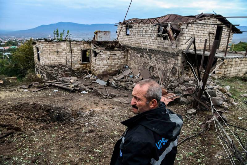 Ashot Aghajanian, 54, stands in the yard of his house destroyed by shelling in Stepanakert.  AFP