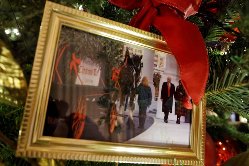 Christmas trees in the State Dining Room are decorated with snapshots of US presidents and their families. This photo shows Donald and Melania Trump. Reuters