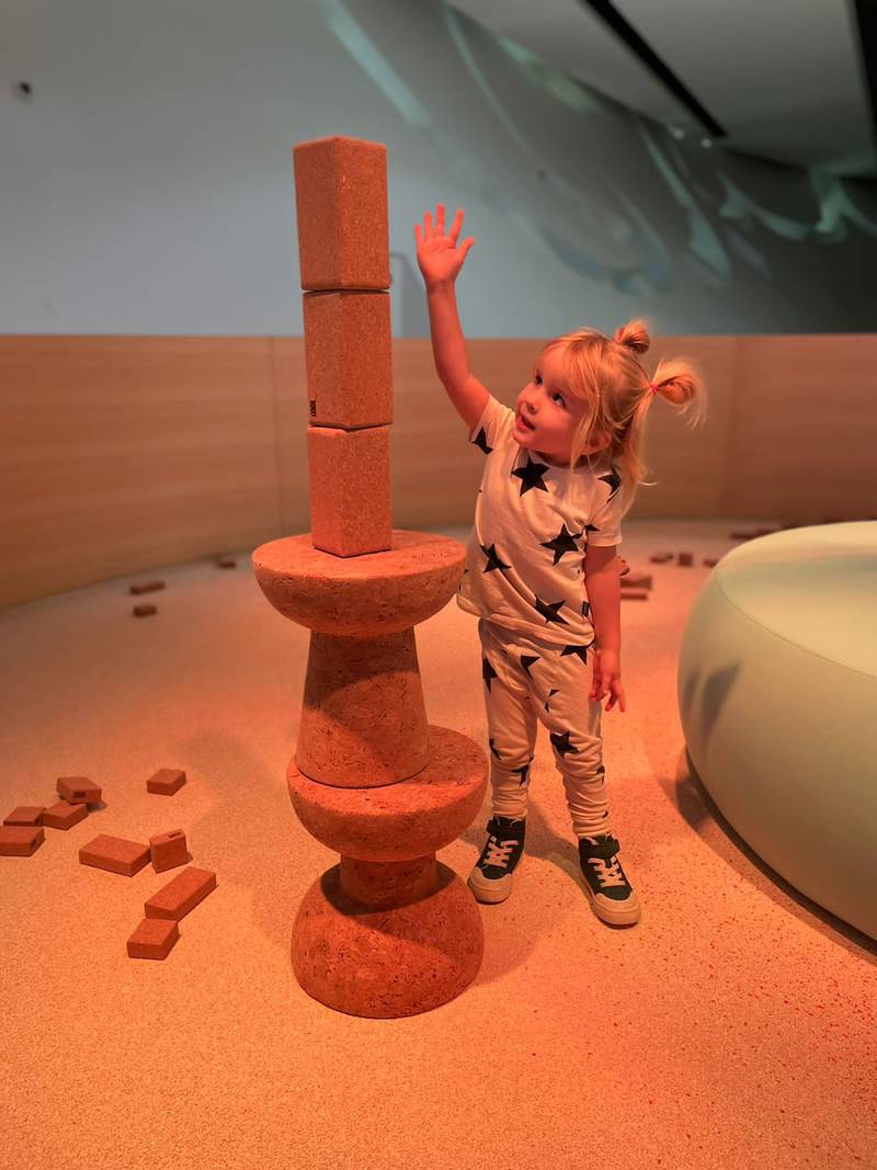 Caspian, 3, builds a tower using the different-sized cork blocks in the area for children aged 3 and under.
