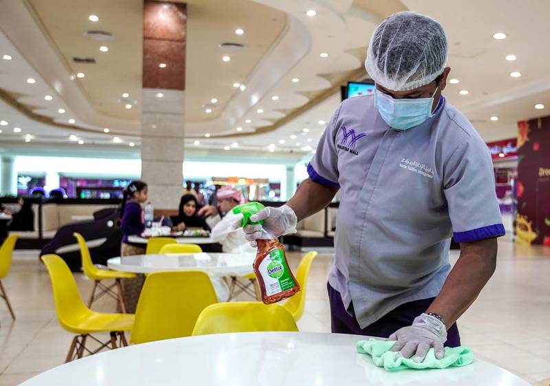 Abu Dhabi, United Arab Emirates, March 11, 2020. A Khalidiyah Mall cleaner disinfects the tables at the foodcourt. to prevent spread of coronavirus.Victor Besa / The NationalSection:  NAReporter:  Kelly Clarke