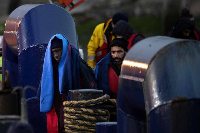 Migrants disembark from an RNLI lifeboat on arrival in Dover, after being picked up at sea. AFP